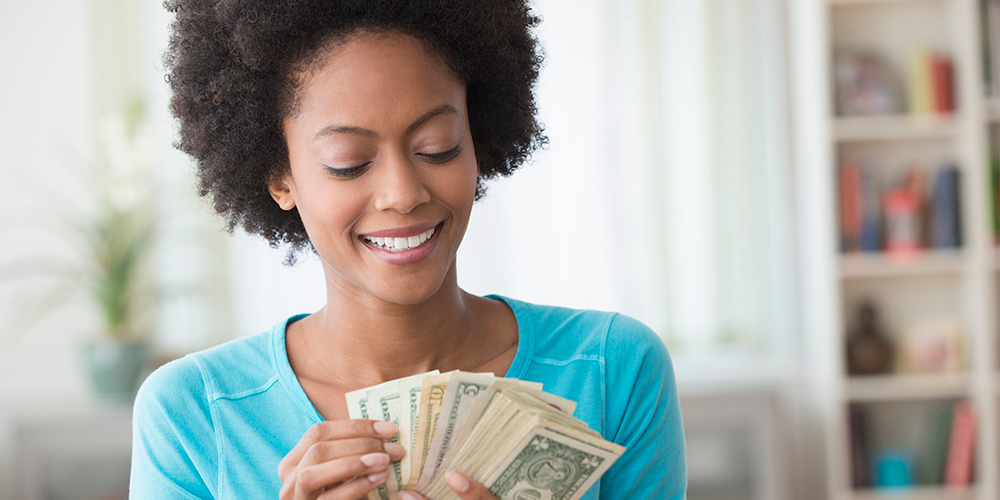 Black woman with Afro counting $1 US bills