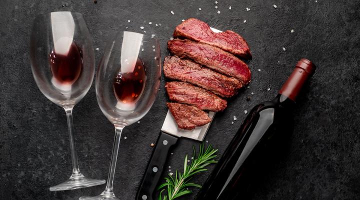 Steak and wine on a black surface