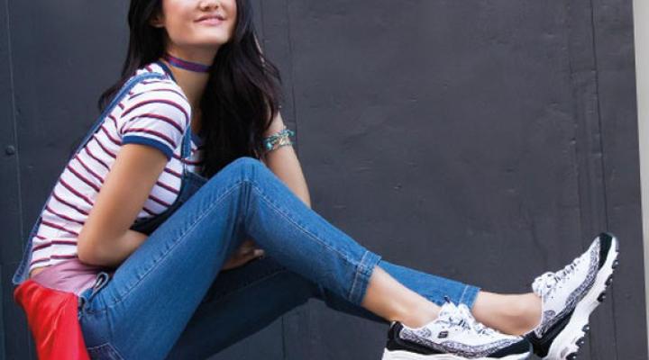 A young woman wearing Skechers sneakers.