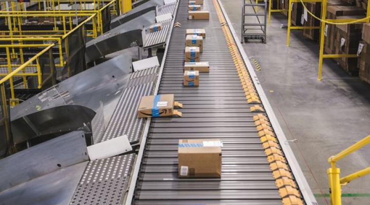 Many Amazon boxes riding a conveyor belt in an Amazon fulfillment center