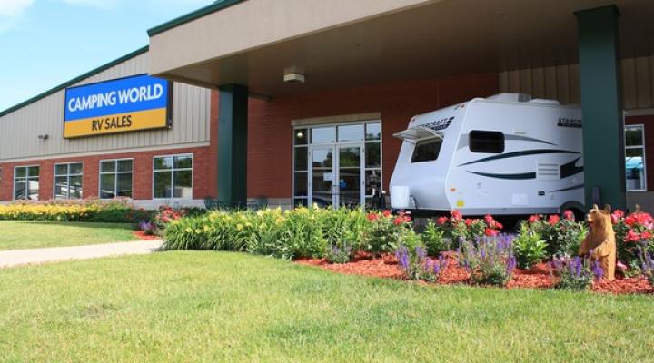 Camping World RV sales sign on a large building with an RV out front