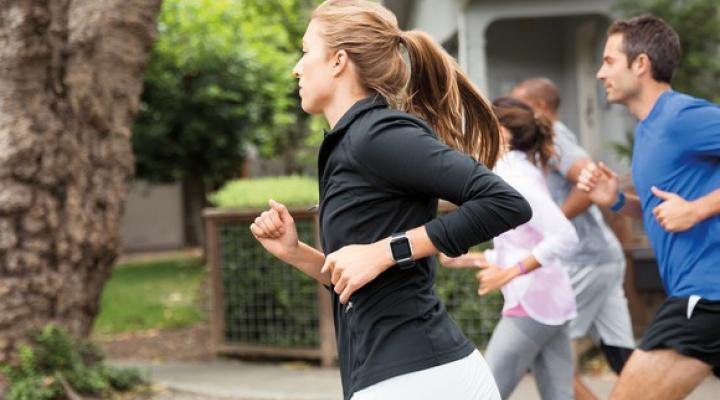 Woman running while wearing Fitbit device