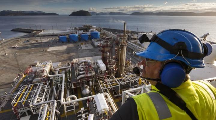 A man looking down from a platform over an energy processing facility.