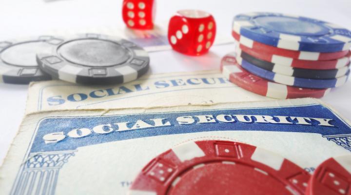 Dice and casino chips lying atop two Social Security cards.