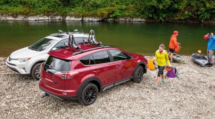 White and red Toyota Rav4s at lake with people ready to go canoeing