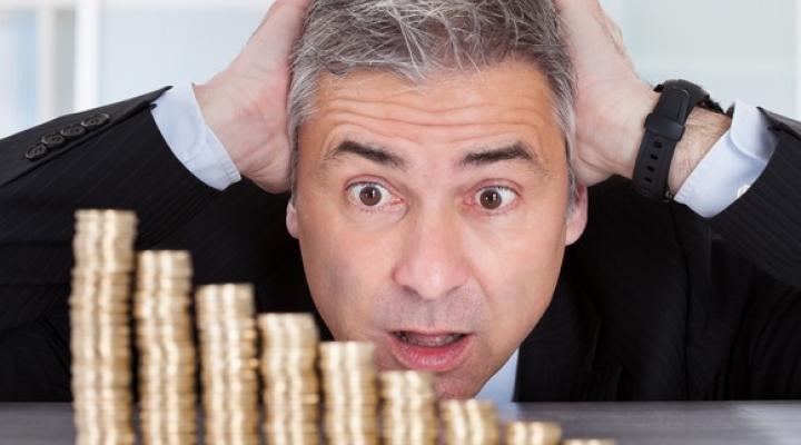 Businessman Losing Money Stacked Coins Getty