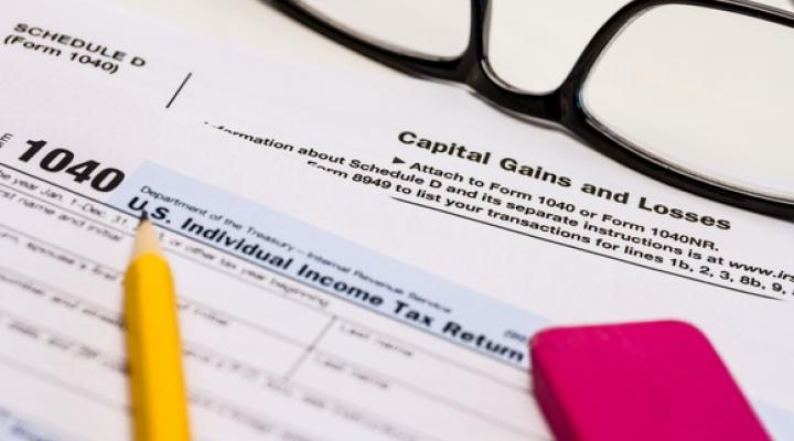 IRS Form 1040 with capital gains tax form. 