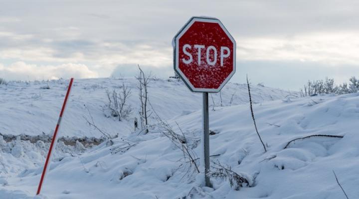 Image shows a stop sign in the snow.