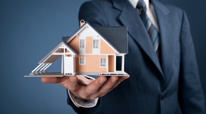 Guy holding 3-D model of house