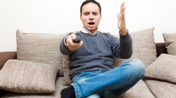 A man appears to be angry at his television.