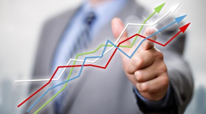 Businessman pointing to line graphs going up