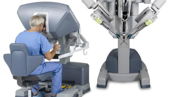 Intuitive Surgical's da Vinci robotic surgical system with man sitting at control station