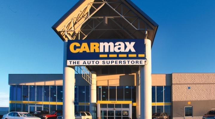 CarMax location with building, large awning, and a few vehicles.