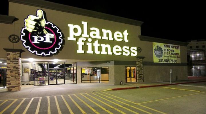 Exterior of a Planet Fitness at night.