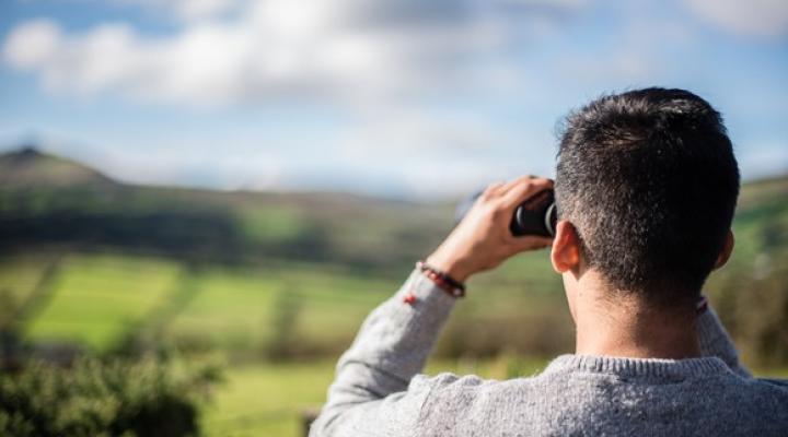 Man with binoculars looking off into the distance