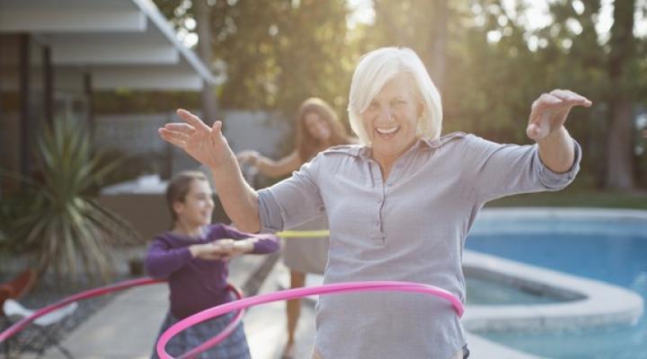 Older woman hoola-hooping with grandchildren