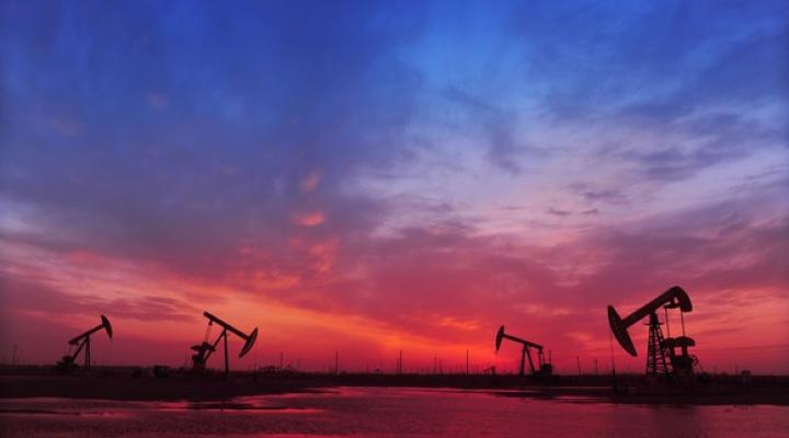 Oil pumps with a red and blue sky above.