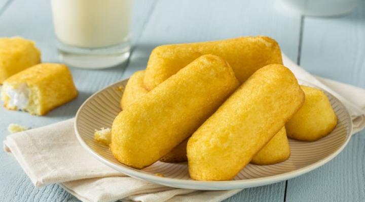 Yellow snack cakes piled up on a plate.