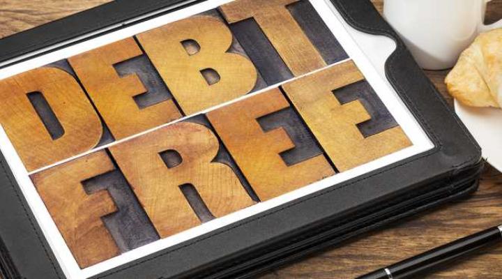 Debt free wooden sign on a tabletop.