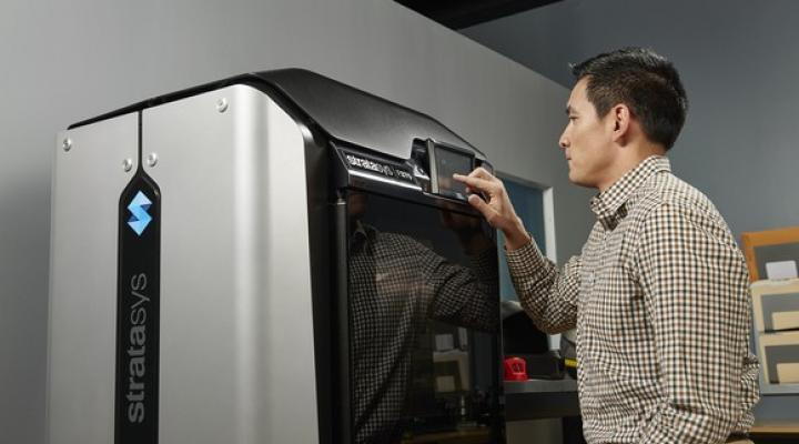 Worker operating a 3D printing machine.