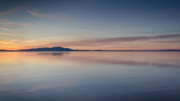 Sunset over lake with mountain in distance