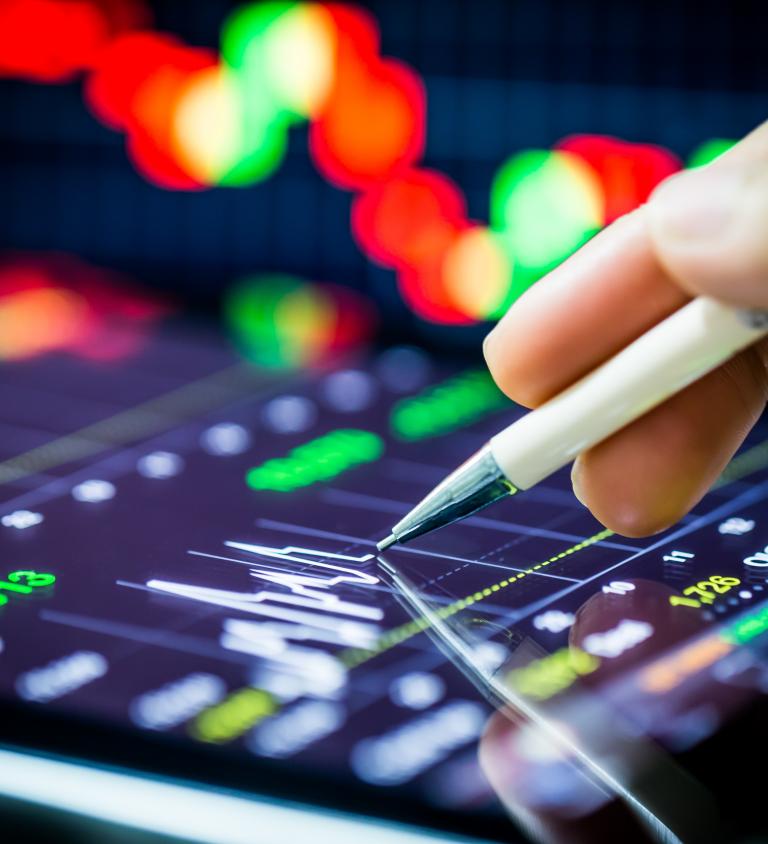 Digital pen on tablet drawing a stock chart